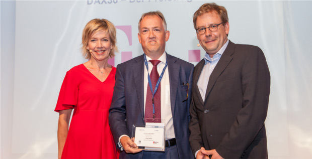 Thomas Ris (Mitte), Vice President Investor Relations der Deutschen Telekom, nimmt den Deutschen Investor Relations Preis entgegen, übergeben vom DIRK-Geschäftsführer Kay Bommer (rechts). Moderiert wurde die Veranstaltung von Corinna Wohlfeil (links).
