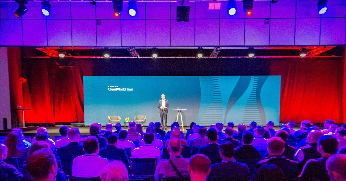 Seien Sie dabei beim Oracle AI World Event am 12. März in Frankfurt. (Foto: Oracle, Speaker auf einer Bühne vor Publikum)